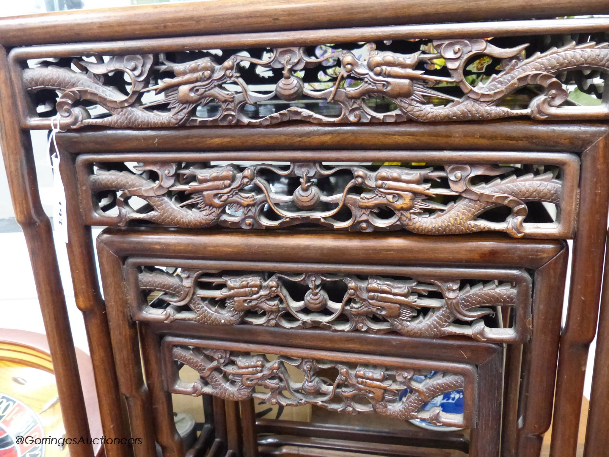 A Chinese nest of four hongmu tables, early 20th century, with a dragon carved freeze, largest table 50.5 cm high, 37 cm deep, 72 cm high